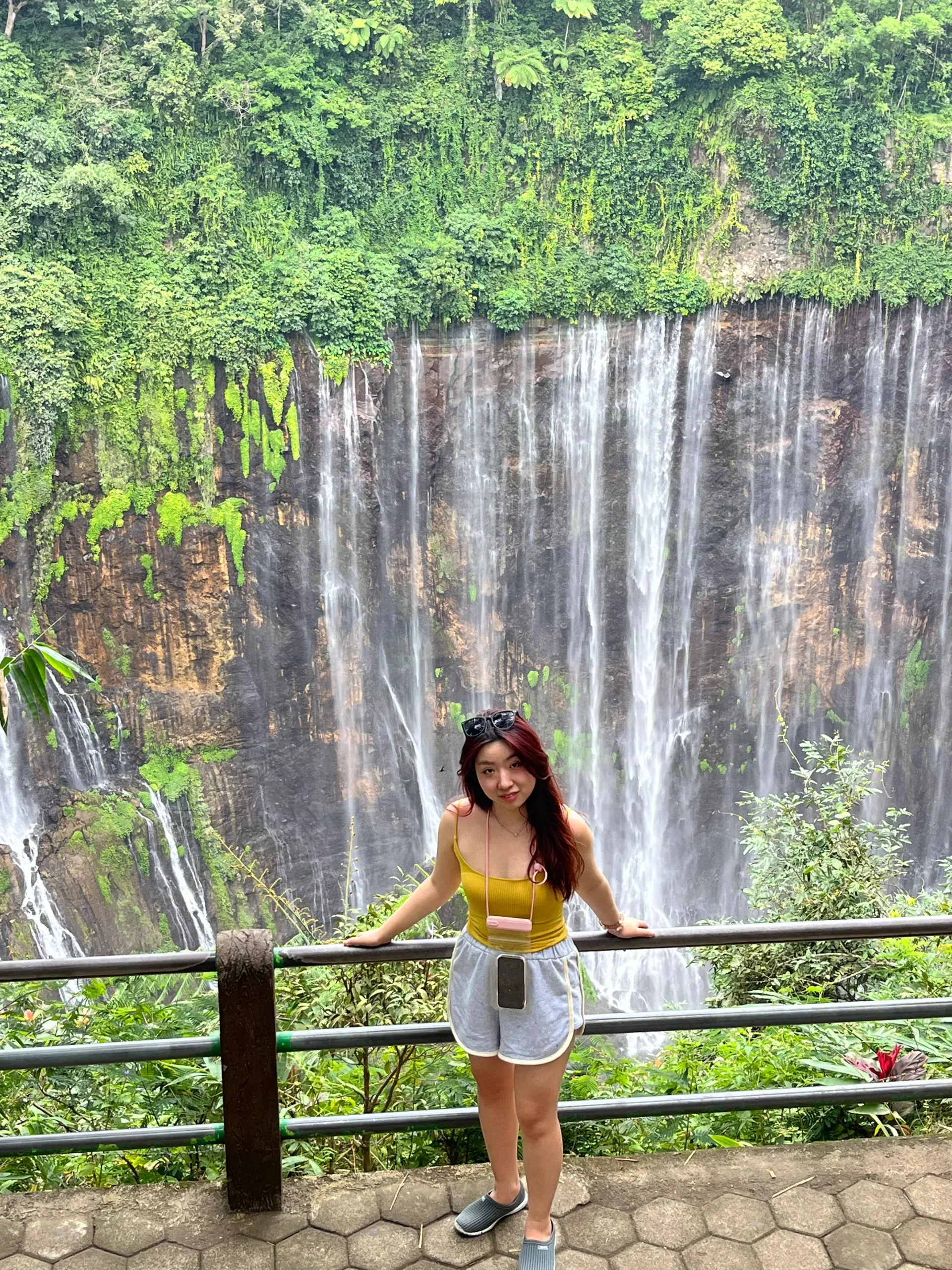 Wisatawan berfoto di pagar Panorama Point dengan latar Air Terjun Tumpak Sewu