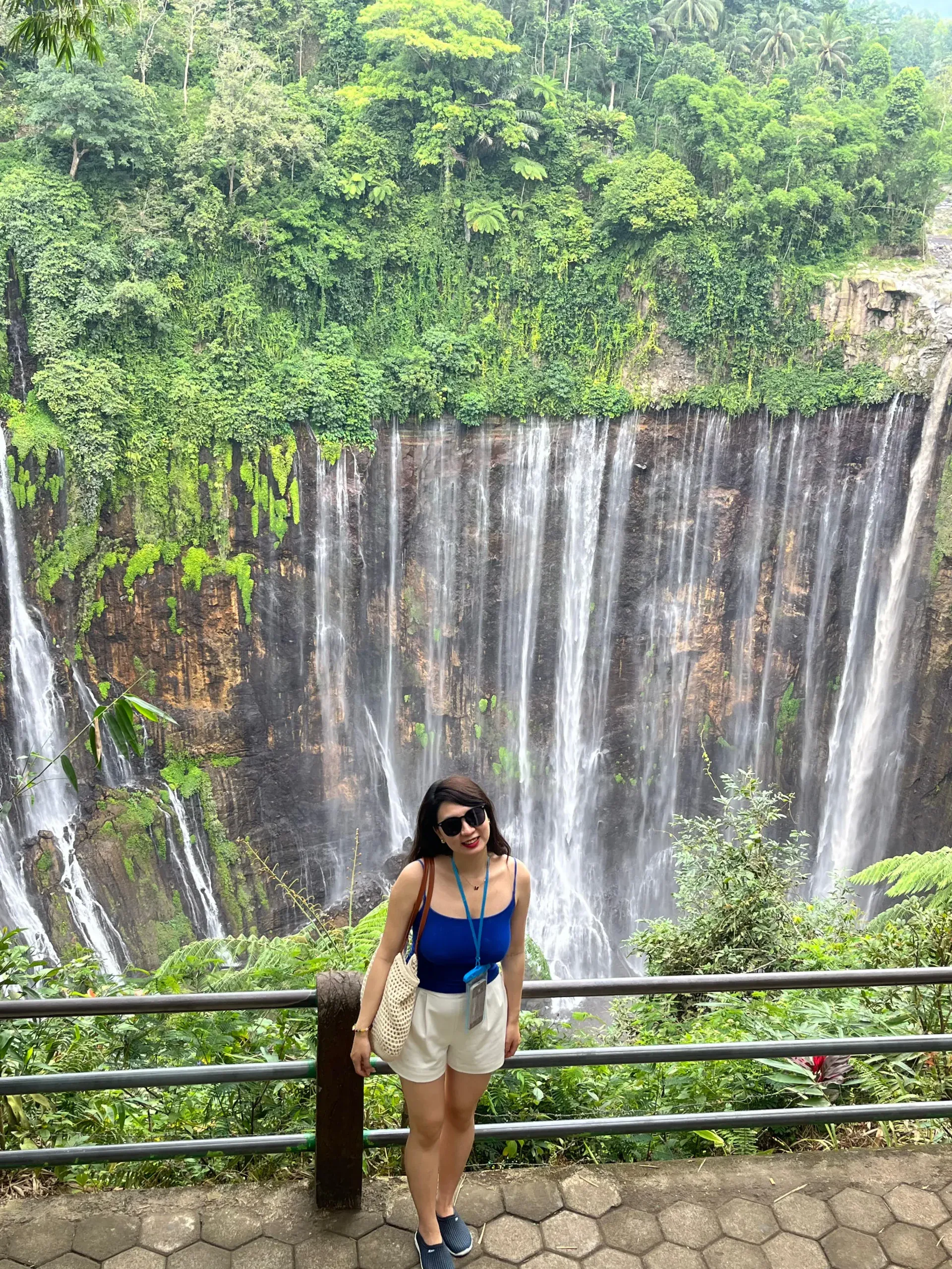 Wisatawan berpose di pagar pandang depan tirai Air Terjun Tumpak Sewu