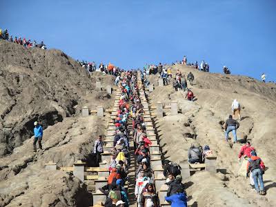 Wisatawan mendaki ratusan anak tangga menuju bibir kawah Bromo yang berpasir.